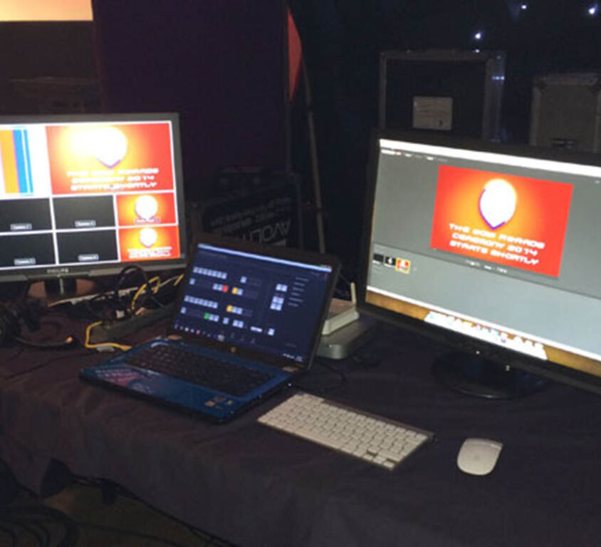 Laptop and screens on a table of equipment showing an example of Conference Craft's technical event management services
