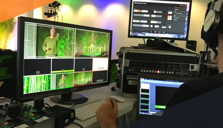 A sustainable corporate event being monitored by a man wearing headphones, reviewing a bank of audio visual equipment.