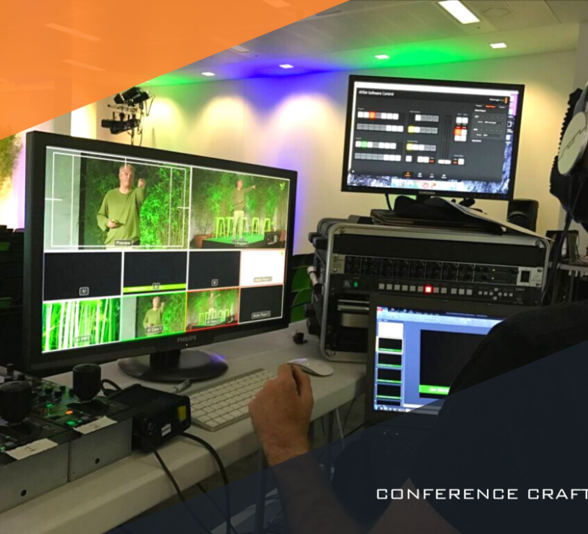 A sustainable corporate event being monitored by a man wearing headphones, reviewing a bank of audio visual equipment.